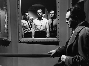 Fred McMurray in the gas chamber in the 1944 film noir classic, Double Indemnity. Edward G. Robinson looks on.
