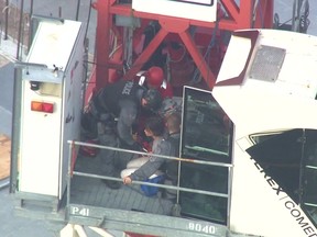 Toronto Police aid a woman who was found in the cab of a crane near Bathurst and Lake Shore on Thursday, Aug. 16, 2018. (CTV screengrab)