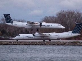 A Porter Airlines plane lands next to a taxiing plane at Toronto's Island Airport.