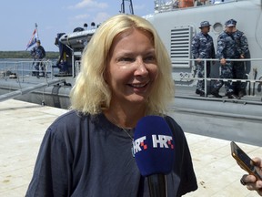 A woman who identified herself as Kay from England, is interviewed by local media in front of a Croatian Coast Guard vessel in the port in Pula, Croatia, on Aug. 19, 2018. (AP Photo)