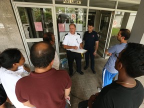 Some of the 1,500 residents of the St. Jamestown high-rise on Parliament St. were allowed to return to their apartments for 10 minutes to gather belongings on Thursday. (Jack Boland/Toronto Sun)