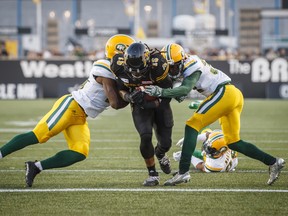 Hamilton Tiger-Cats’ head coach June Jones likes all his options at running back, but prefers to find the hot hand and stick with it. Lately, that has been Alex Green (centre) and he’s more than happy to carry the load.(The Canadian Press)