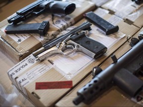 Police display guns seized during a series of raids at a press conference in Toronto on Friday, June 14, 2013. (THE CANADIAN PRESS/Chris Young)