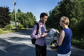 Omer Malik accepts a hat from Janet McFetridge, one of the most visible refugee advocates, before continuing to the end of Roxham Road and illegally crossing into Canada. Malik came to the United States from Ghazni, Afghanistan. (Andre Malerba/The Washington Post)