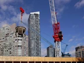 Toronto, Canada - November 4, 2016:  A construction crane lifts a cement bucket on a construction site for a new high rise condo building for Toronto's booming housing market.