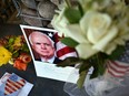Photographs, flowers and notes gather at a makeshift memorial to U.S. Sen. John McCain outside his office in Phoenix, Ariz., on Aug. 26, 2018.