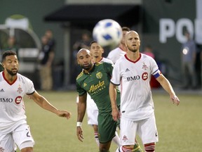 Portland Timbers' Samuel Armenteros watches the ball as he stands between Toronto FC's Michael Bradley (4) and Justin Morrow (2) during an MLS soccer match Wednesday, Aug. 29, 2018, in Portland, Ore. (Sean Meagher/The Oregonian via AP)