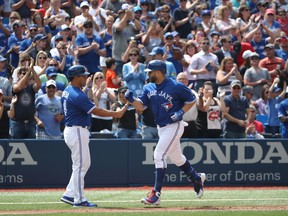 Blue Jays’ Kendrys Morales is congratulated by third base coach Luis Rivera after hitting a solo home run in the seventh inning against the Baltimore Orioles on Wednesday, Aug. 22, 2018. Morales is the 15th Blue Jays player to hit a home run in at least fourth consecutive games. (Tom Szczerbowski/Getty Images)