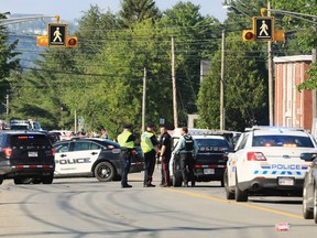 Police officers survey the area of a shooting in Fredericton, N.B. on Friday, August 10, 2018. THE CANADIAN PRESS/Keith Minchin