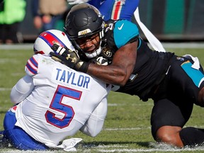 In this Jan. 7, 2018, file photo, Jaguars defensive end Yannick Ngakoue, right, draws a penalty by hitting Bills quarterback Tyrod Taylor (5) with during NFL playoff action, in Jacksonville, Fla.