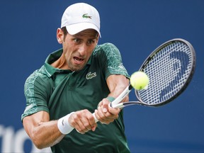 Novak Djokovic returns a shot to Mirza Basic during the first round of the Rogers Cup tennis tournament in Toronto on Tuesday. THE CANADIAN PRESS