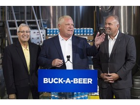 Ontario Premier Doug Ford, centre, Vic Fedeli, left, and Todd Smith announce the buck-a-beer plan at Barley Days brewery in Picton, Ont. on Tuesday, Aug. 7, 2018.