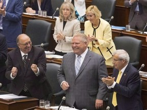 Ontario Premier Doug Ford is applauded by his PC Party members during question period at the Ontario legislature in Toronto on July 30, 2018.