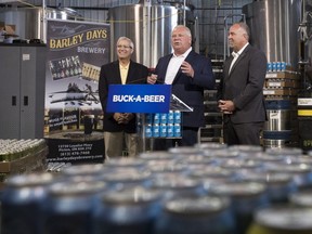 Ontario Premier Doug Ford, centre, Vic Fedeli, left, and Todd Smith announce the buck-a-beer plan at Barley Days brewery in Picton, Ont. on Tuesday, Aug. 7, 2018. THE CANADIAN PRESS/Lars Hagberg