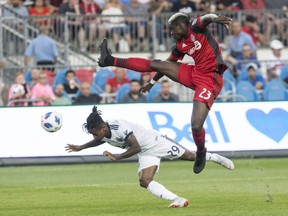 Vancouver Whitecaps forward Yordi Reyna, left, dives to get a header in front of Toronto FC defender Chris Mavinga during first half action in the Canadian Championship Final's second leg in Toronto on Wednesday, August 15, 2018. THE CANADIAN PRESS/Chris Young