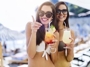 Girls drinking cocktails on beach