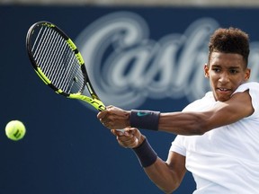 Felix Auger-Aliassime, of Canada, returns a shot to Lucas Pouille, not shown, of France, during the first round of the Men's Rogers Cup tennis tournament in Toronto, Tuesday, August 7, 2018.