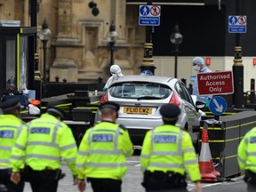 London police approach the suspect car in what was described as a terror attack in the British capital Tuesday.