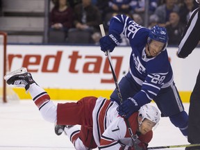 Ex-Leaf Dominic Moore battles for the puck with Carolina’s Derek Ryan last season.  Stan Behal/PToronto Sun files