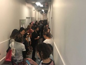 A crowd of people take shelter in a staff corridor following reports of gun shots at Yorkdale Shopping Centre in Toronto on Thursday, Aug. 30, 2018. A shooting at a major Toronto mall on Thursday afternoon sent shoppers running for cover as police searched for multiple suspects. No one was injured in the gunfire that police said took place on the east side of the Yorkdale Shopping Centre just before 3 p.m.
