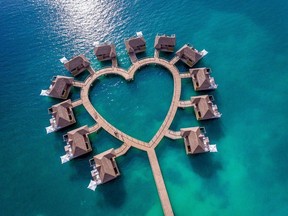 The 12 overwater bungalows at Sandals South Coast are arranged in a heart shape and connected to the beach by a wooden pier.