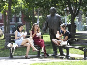 Women enjoy lunch in the newly upgraded Bellevue Park in Kensington Market, joined by the neglected statue of Al Waxman, "The King of Kensington" on Tuesday, Aug. 7 2018.(Jack Boland/Toronto Sun)