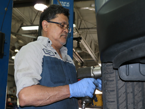 Kishor Patel, a service technician at Mississauga Hyundai, removes the wheels of a Santa Fe SUV prior to a brake inspection.