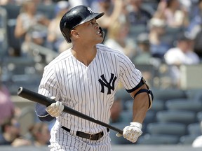 New York Yankees slugger Giancarlo Stanton watches his solo home run off Toronto Blue Jays starting pitcher Sean Reid-Foley Saturday, Aug. 18, 2018, in New York. (AP Photo/Julio Cortez)