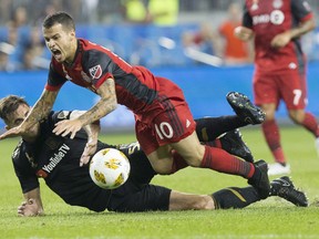 Toronto FC's Sebastian Giovinco is brought down by Los Angeles FC's Dejan Jakovic during Saturday's game. (THE CANADIAN PRESS)