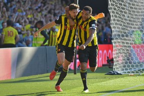 Watford's Craig Cathcart (left) celebrates with Troy Deeney after scoring the game-winning goal against Tottenham Hotspur on Sunday. (GETTY IMAGES)