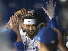 Lourdes Gurriel Jr. #13 of the Toronto Blue Jays is congratulated by teammates in teh dugout after hitting a solo home run in the first inning during MLB game action against the Tampa Bay Rays at Rogers Centre on September 21, 2018 in Toronto, Canada.
