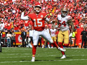Patrick Mahomes of the Kansas City Chiefs throws on the run for a touchdown while Cassius Marsh  of the San Francisco 49ers is in pursuit during the second quarter of the game at Arrowhead Stadium on September 23rd, 2018 in Kansas City, Missouri. (Photo by Peter Aiken/Getty Images)