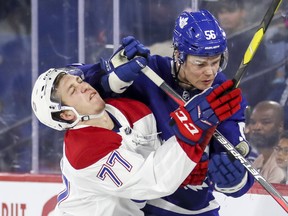 Montreal Canadiens' Will Bitten takes a forearm to the head from the Leafs' Andrew Nielson during Sunday's game. (JOHN MAHONEY/Postmedia Network)