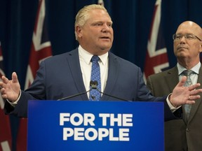 Ontario Premier Doug Ford speaks to reporters as Municipal Affairs Minister Steve Clark looks on. (The Canadian Press)