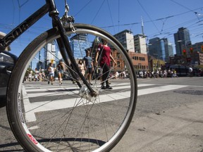 Cyclists and pedestrians at the corner of Spadina Ave. and Queen St. W. in Toronto on Sept. 16, 2018. (Ernest Doroszuk, Toronto Sun)