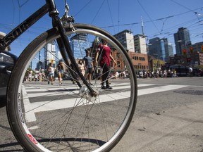 Cyclists and pedestrians at the corner of Spadina Ave. and Queen St. W. (Ernest Doroszuk, Toronto Sun)