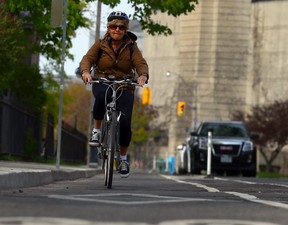 Sue-Ann Levy rides her bike in the designated bike lane on Harbord St. in Toronto on May 10, 2016. (Dave Abel, Toronto Sun)