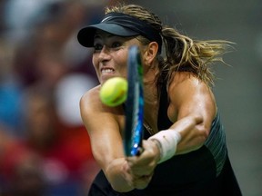 Russia's Maria Sharapova hits a return to Spain's Carla Suarez Navarro during their 2018 US Open Women's Singles tennis match at the USTA Billie Jean King National Tennis Center in New York on September 3, 2018.
