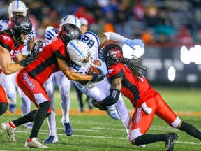 Argonauts’ Malcolm Williams is tackled by the Stampeders’ Troy Stoudermire in Calgary on Friday night.  Al Charest/Postmedia Network