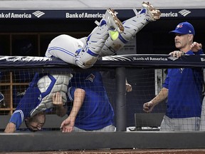 Toronto Blue Jays catcher Luke Maile goes over the railing into the dugout chasing a foul pop Friday, Sept. 14, 2018, at Yankee Stadium in New York. (AP Photo/Bill Kostroun)