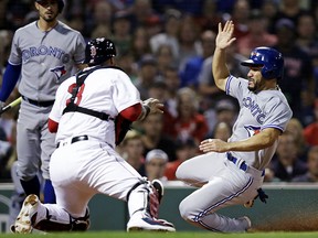 Toronto Blue Jays' Devon Travis, right, scores as Boston Red Sox catcher Sandy Leon, left, waits for the ball at Fenway Park in Boston, Tuesday, Sept. 11, 2018. (AP Photo/Charles Krupa)