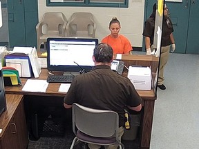 This photo from video released Thursday, Sept. 13, 2018, by the Kaufman County Sheriff's Office in Kaufman, Texas, shows Dallas police Officer Amber Guyger getting booked after turning herself in Sunday, Sept. 9 following the fatal shooting of Botham Jean in his own apartment.