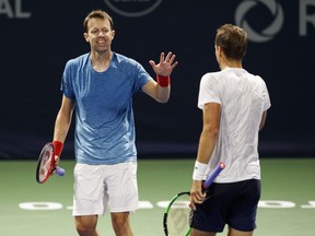 Canada's Daniel Nestor, left, and Vasek Pospisil, high five as they play Feliciano Lopez and Marc Lopez, of Spain, during Men's Rogers Cup doubles action in Toronto, Aug. 8, 2018.