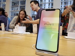 In this Nov. 3, 2017, file photo, customers buy the iPhone X at the Apple Store on New York's Fifth Avenue. (AP Photo/Richard Drew, File)