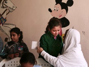In this Wednesday, Feb. 25, 2015, file, photo, Maggie Gobran, known as "Mama Maggie," comforts a child at a community development centre she founded in the Manshiet Nasr, neighbourhood of Cairo, Egypt.