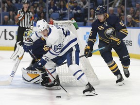 Maple Leafs centre Tyler Ennis is chased by defenceman Rasmus Ristolainen as he handles the puck beside the Sabres net on Saturday night in Buffalo. (Adrian Kraus/The Associated Press)