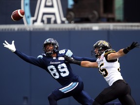 Toronto Argonauts wide receiver Duron Carter (89) reaches for an overthrown ball against Hamilton Tiger-Cats defensive back Mike Daly (35) during first half CFL football action against the Hamilton Tiger-Cats, in Toronto, Saturday, Sept. 8, 2018. THE CANADIAN PRESS/Cole Burston