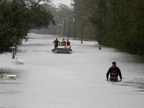 A member of the U.S. Coast Guard walks down Mill Creek Rd. checking houses after tropical storm Florence hit Newport, N.C., Saturday, Sept. 15, 2018.