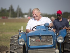 Ontario Premier Doug Ford makes the turn after plowing a stretch of land on a Ford 3000 tractor at the 2018 International Plowing Match and Rural Expo in Pain Court outside Chatham on Tuesday