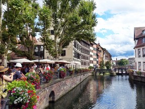 Strasbourg's half-timbered buildings provide a Germanic backdrop for an Alsatian meal on this riverfront terrace. (Rick Steves photo)